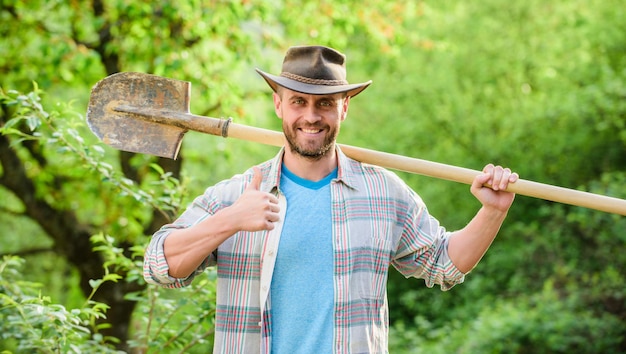 Granja ecológica. Cosecha. granjero sexy sostenga la pala. agricultura y cultivo agrícola. Equipo de jardinería. feliz día de la Tierra. Vida ecológica. hombre de rancho musculoso con sombrero de vaquero. Jardinero en el trabajo.