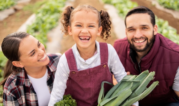 Granja familiar y retrato de padres felices con un hijo en una plantación agrícola lista para la cosecha Sostenibilidad del jardín y agricultor madre y padre vinculándose con un niño en un jardín de invernadero en la naturaleza