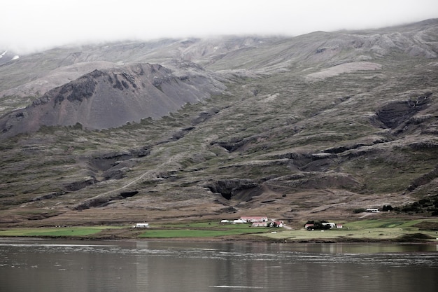 Granja de paisaje islandés en montañas nubladas