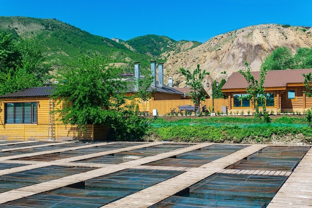 Granja de peces en un valle de montaña con jaulas de acuicultura y edificios de madera