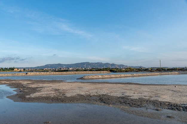 Granjas de acuicultura y tierra alcalina salina junto al mar bajo el cielo azul