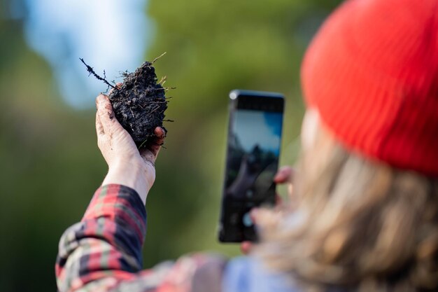 Granjera usando tecnología para probar el suelo Granjero tomando una foto de una muestra de suelo Sosteniendo el suelo en una mano en Australia