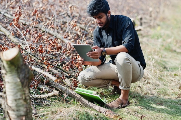 Granjero agrónomo del sur de Asia con portapapeles inspeccionando árboles cortados en el jardín agrícola Concepto de producción agrícola