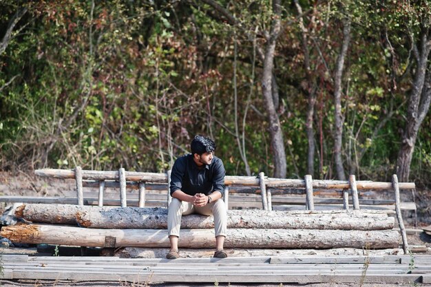 Granjero agrónomo del sur de Asia sentado en el bosque en la granja Concepto de producción agrícola