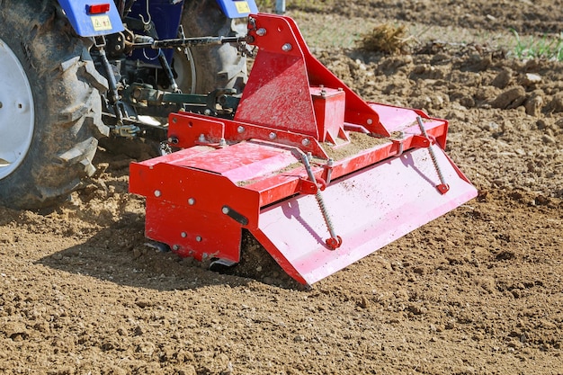 Granjero ara el campo. Pequeño tractor con arado en el campo. Cultivo.