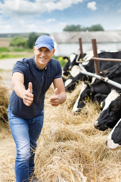 Granjero feliz entre vacas