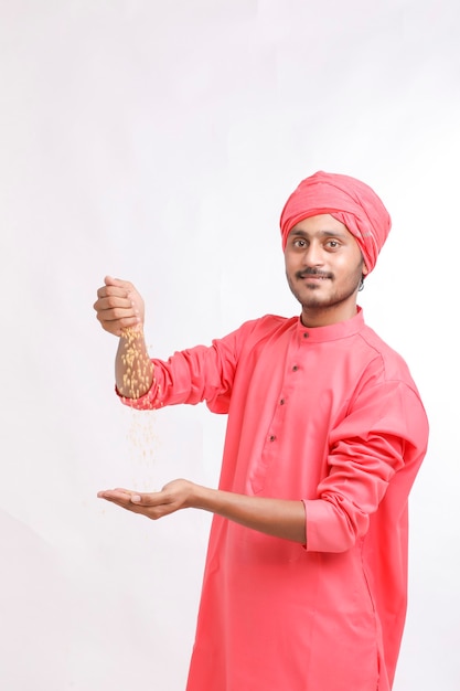 Granjero indio con trigo en la mano y sonriendo.