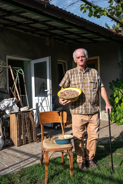 Granjero Senior sosteniendo un tazón de frijoles al aire libre