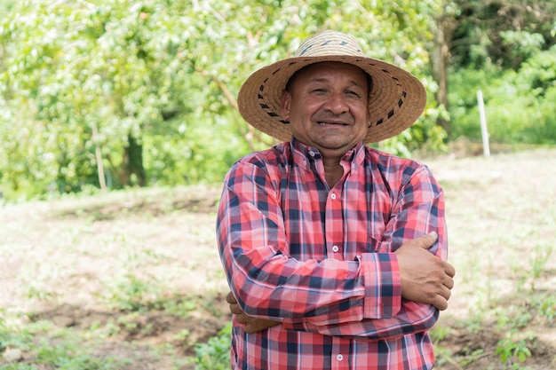 Granjero sonriente de pie sobre un cultivo