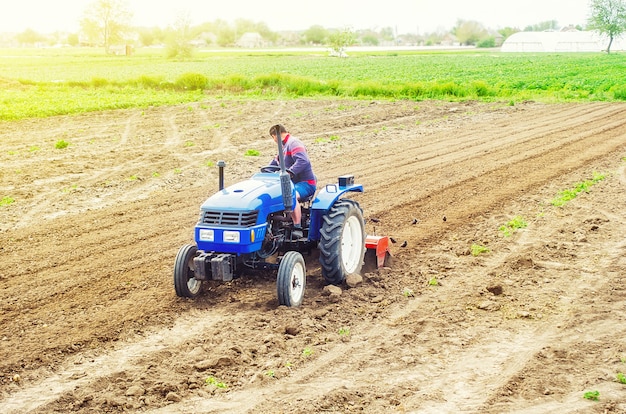 Un granjero en un tractor cultiva un campo agrícola.