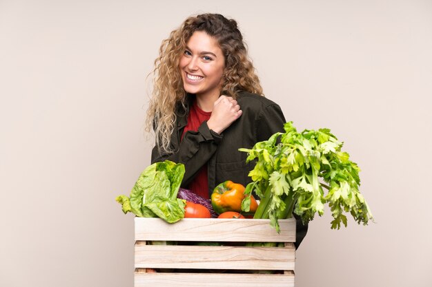 Granjero con verduras frescas en una caja aislada