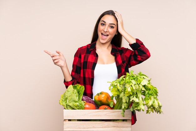 Granjero con verduras recién cogidas en una caja