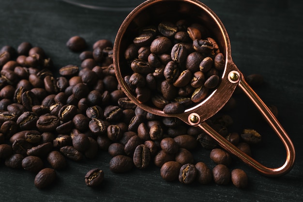 Grano de café en una cuchara de cobre