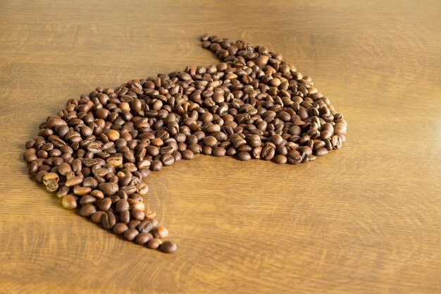 Grano de café marrón sobre un fondo de madera closeup