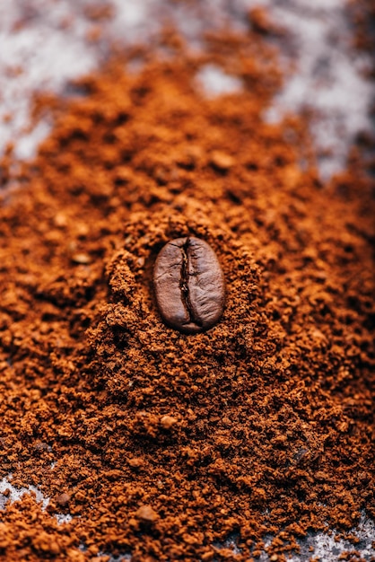 Foto grano de café en un montón de café molido