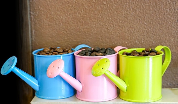 Grano de café en una olla de ducha de decoración pequeña y colorida en el fondo de la pared