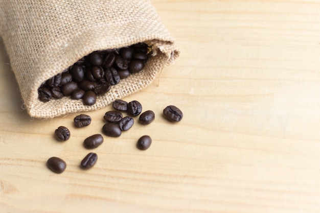 Grano de café en saco en el espacio de copia de mesa de madera