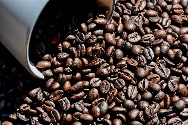 Grano de café en taza en el escritorio de madera