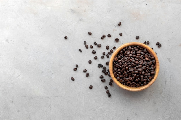 Grano de café en taza de madera en fondo del escritorio