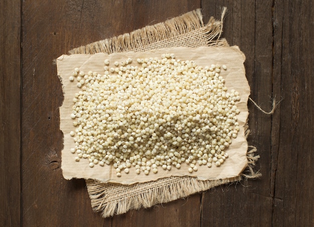 Grano de sorgo blanco en la mesa de madera de cerca