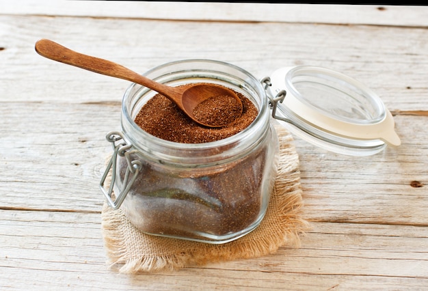 Grano de teff crudo en un frasco de vidrio con una cuchara