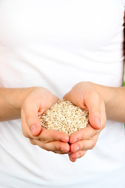 Grano de trigo en manos femeninas en superficie natural