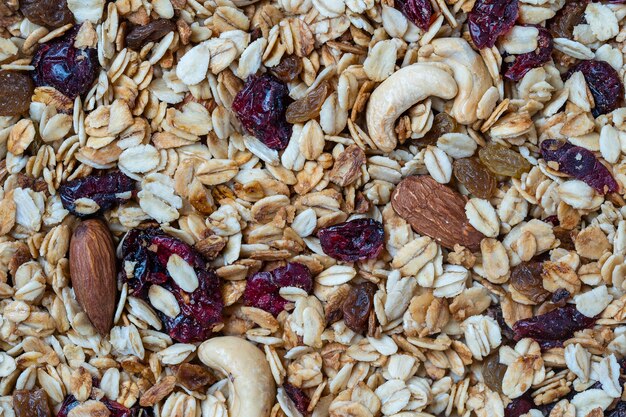 Granola con avena, frutos secos, miel, pasas, arándano seco, almendras y anacardos, de cerca, vista superior. Concepto de desayuno saludable