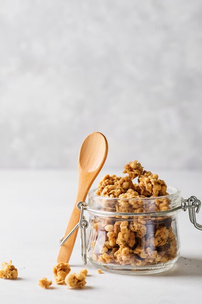 Granola de avena en tarro de cristal sobre fondo blanco cerca del espacio de copia