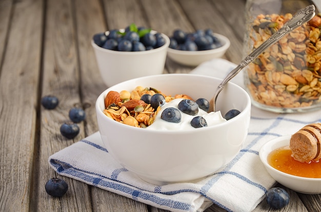 Granola caseiro com iogurte e frutas frescas, conceito de café da manhã saudável.