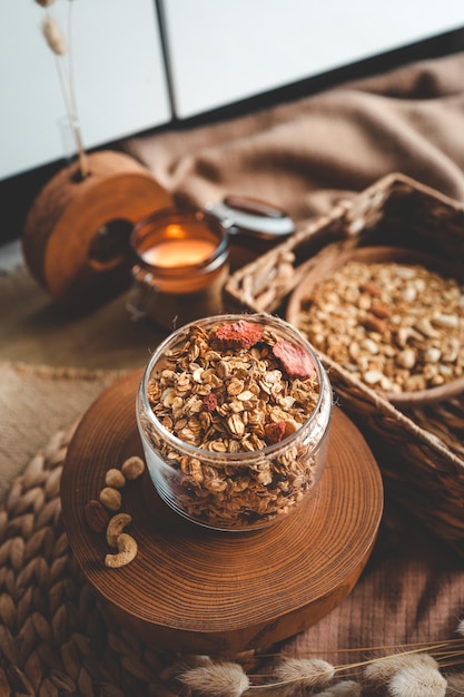 Granola casera en un frasco de vidrio con el trasfondo de velas de leche y decoración concepto de buenos días