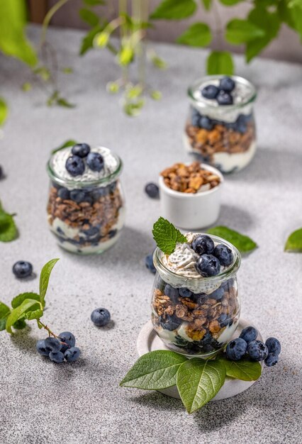 Granola casera con jarabe de arce de yogur griego y moras y arándanos frescos en vasos