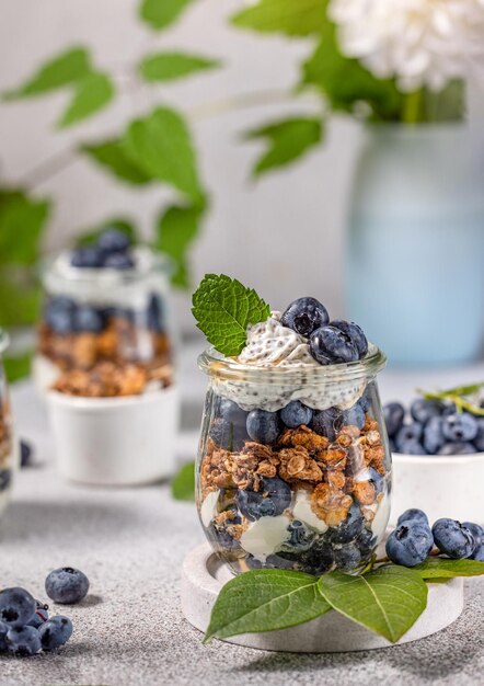 Granola casera con jarabe de arce de yogur griego y moras y arándanos frescos en vasos