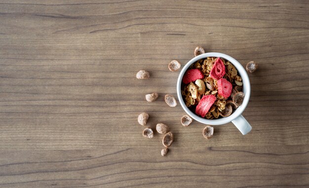 Granola casera con leche para el desayuno en la mesa de madera. vista superior