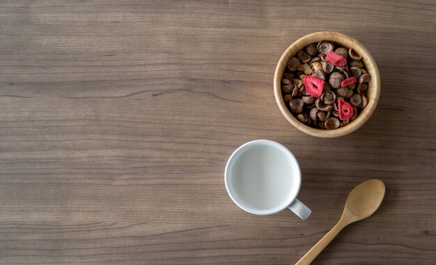 Granola casera con leche para el desayuno en la mesa de madera. vista superior