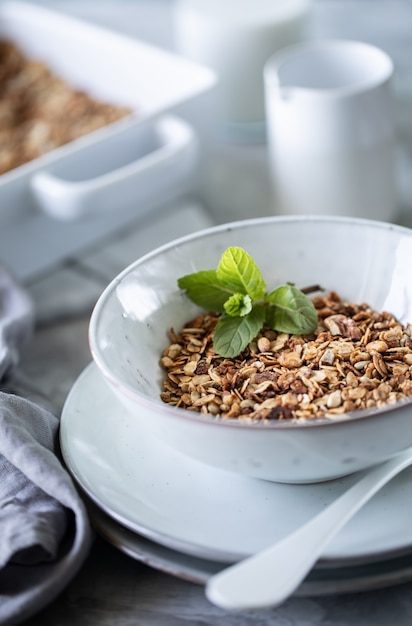 Granola casera en plato blanco. Desayuno saludable con granola, yogurt, frutas, bayas en un plato blanco