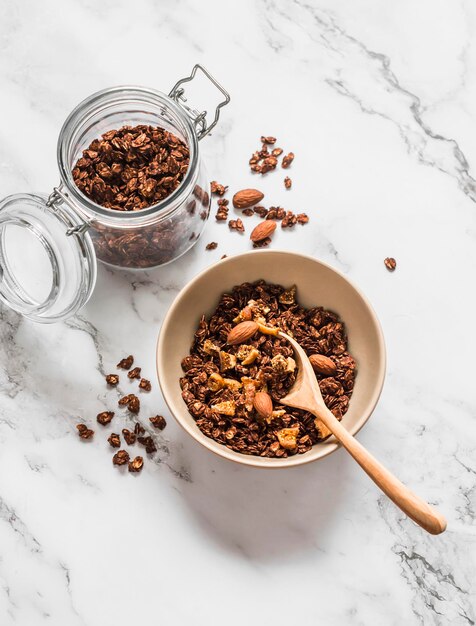 Granola de chocolate casera con higos secos de avena y almendras en una vista superior de fondo claro