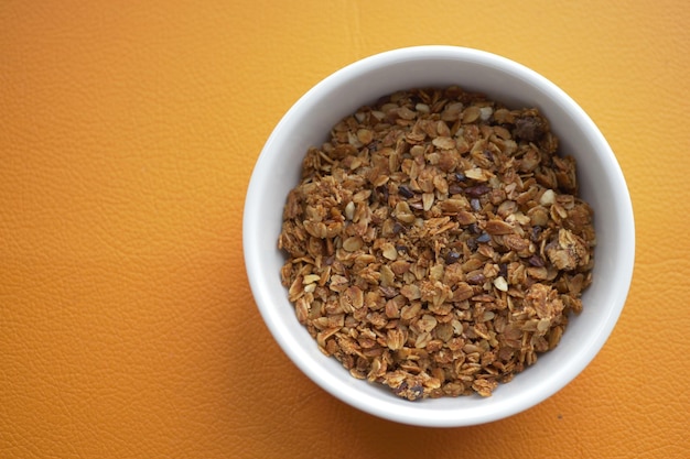 Granola de chocolate Musli en un recipiente sobre fondo naranja