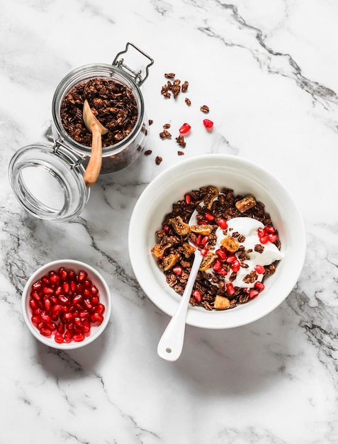 Granola de chocolate con yogur griego, granada, higos secos, delicioso desayuno en una vista superior de fondo claro