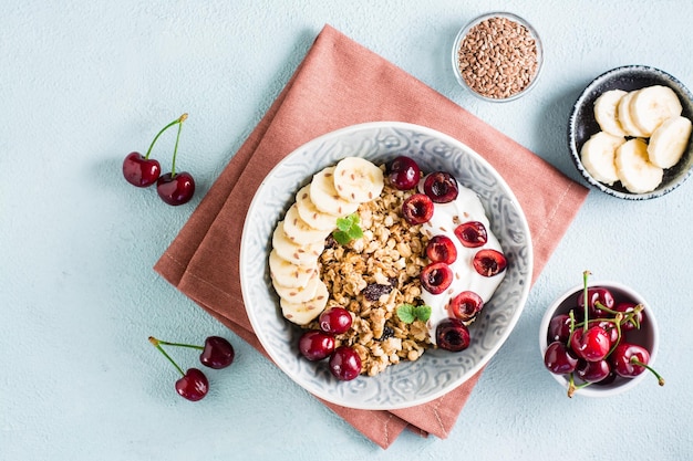 Granola com banana cereja e sementes de linho em uma tigela na mesa Café da manhã caseiro Vista superior