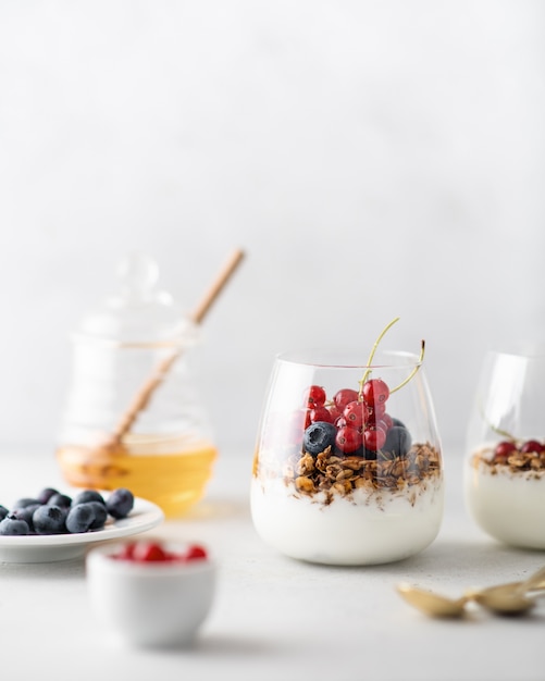 Granola com iogurte, frutas vermelhas e mel em um copo