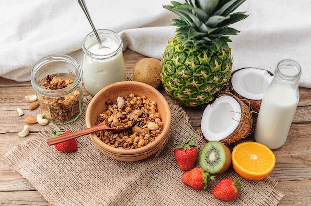 Granola com iogurte grego e frutas em fundo de madeira em estilo rústico