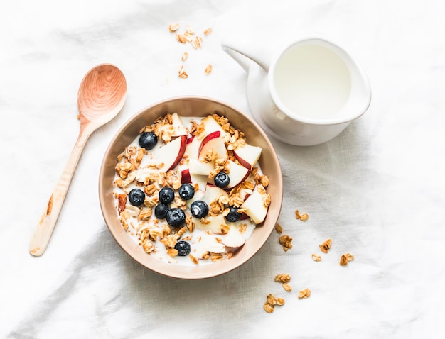 Granola de manteiga de amendoim com leite, maçãs e mirtilos, café da manhã ou lanche de energia saudável