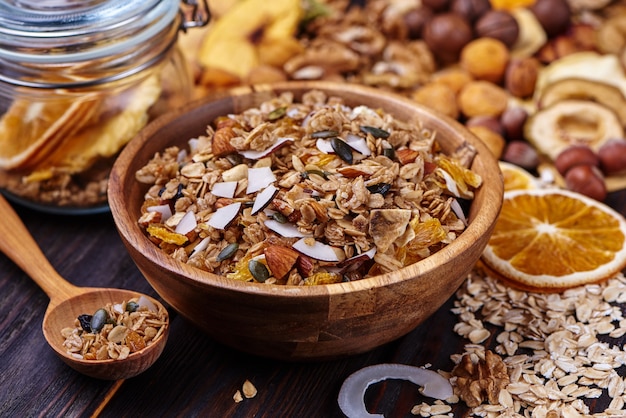 Granola e frutas secas com nozes em uma mesa de madeira