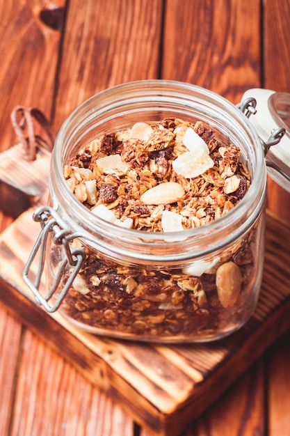 Granola em uma jarra sobre a mesa de madeira close-up