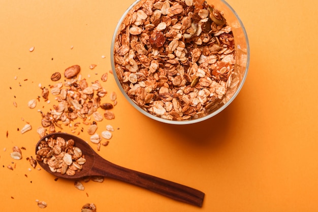 Granola en un frasco de vidrio sobre un fondo amarillo