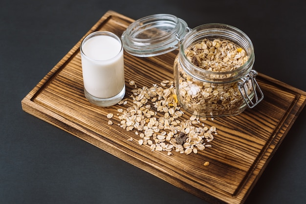 Granola en un frasco de vidrio con un vaso de leche.