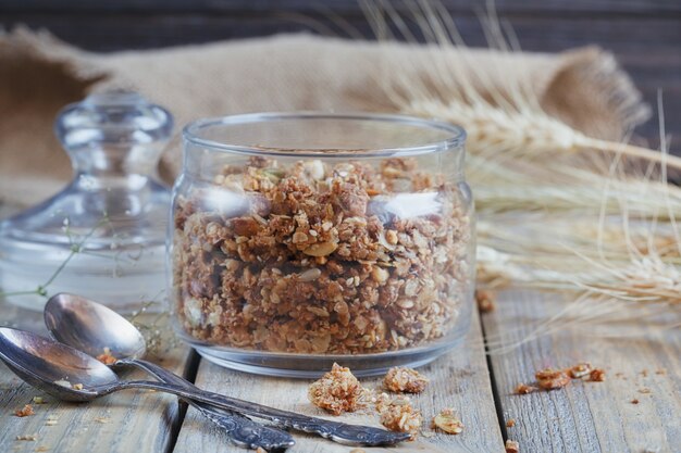 Granola, frutas e espigas de trigo e aveia.