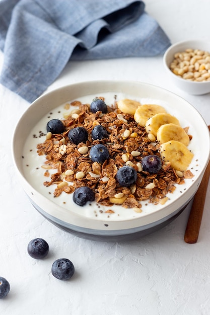 Granola mit Joghurt, Blaubeeren, Nüssen, Banane und Honig. Müsli. Gesundes Essen. Vegetarisches Essen.