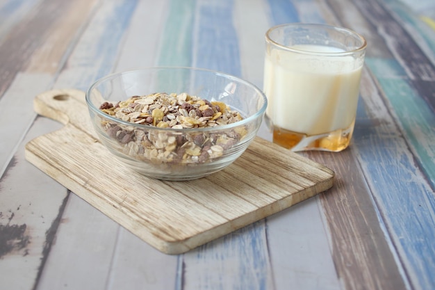 Granola Musli en un bol y un vaso de leche en la mesa