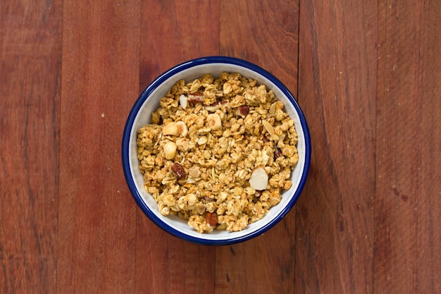 Granola na tigela na superfície de madeira marrom